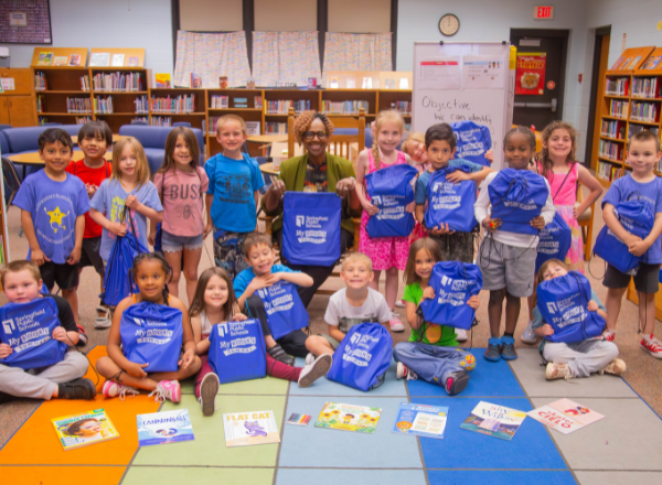  Dr. Lathan is surrounded by kindergarteners and their book bundles